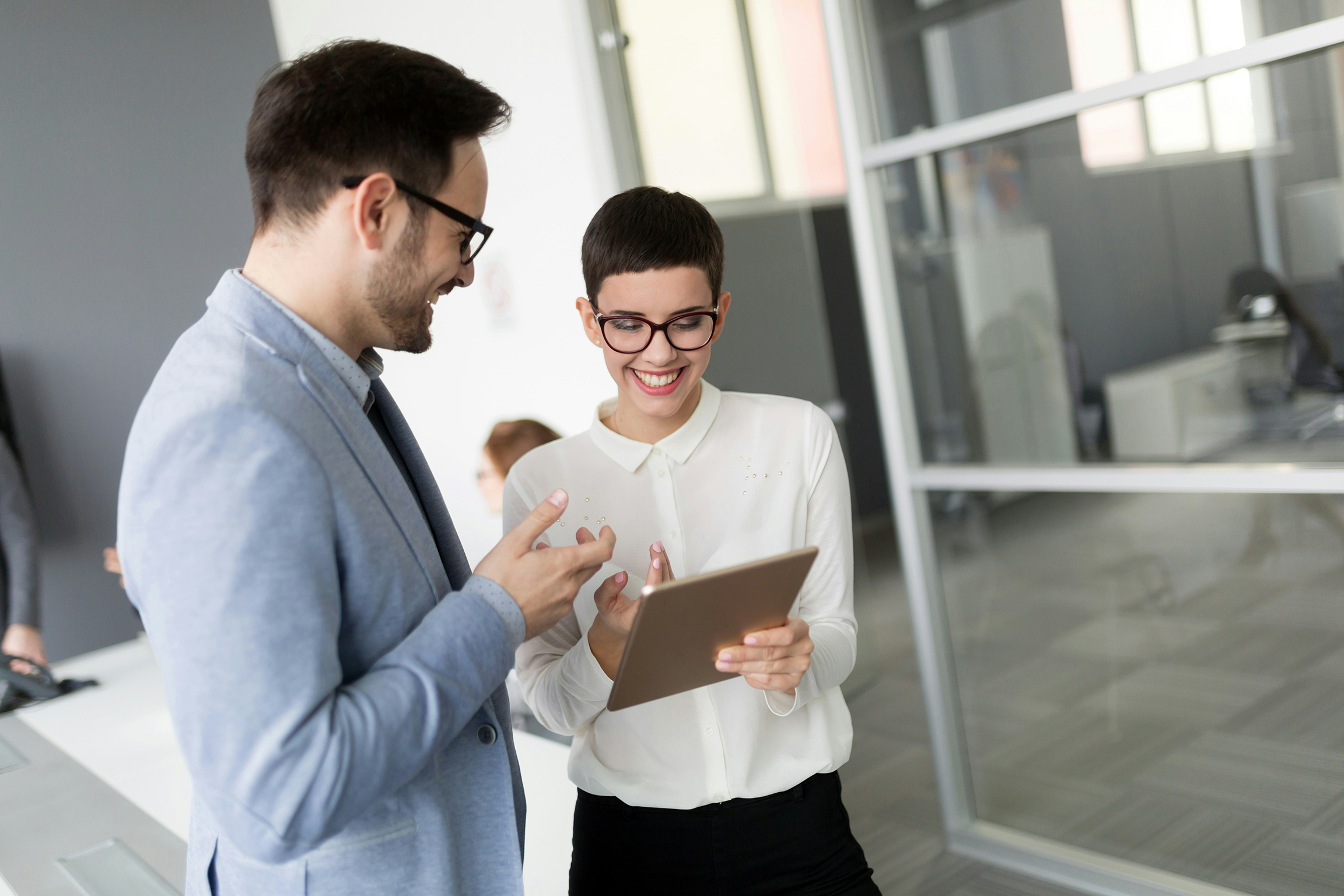 Two colleagues reviewing figures on a tablet
